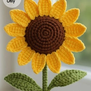 Puede incluir: Un girasol tejido a ganchillo con pétalos amarillos y un centro marrón. El tallo y las hojas son verdes. La imagen incluye el texto "Pattern Only" en un círculo blanco.