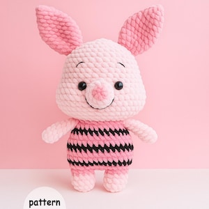 May include: A handmade pink crochet pig with large ears, black eyes, and a striped black and pink shirt. The text "pattern Only" is in a white circle at the bottom. The pig is standing against a pink background.