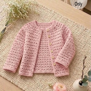 May include: A light pink crochet cardigan with long sleeves and wooden buttons. The open-front sweater is displayed on a textured beige surface. The text "Pattern Only" is in the upper right corner.