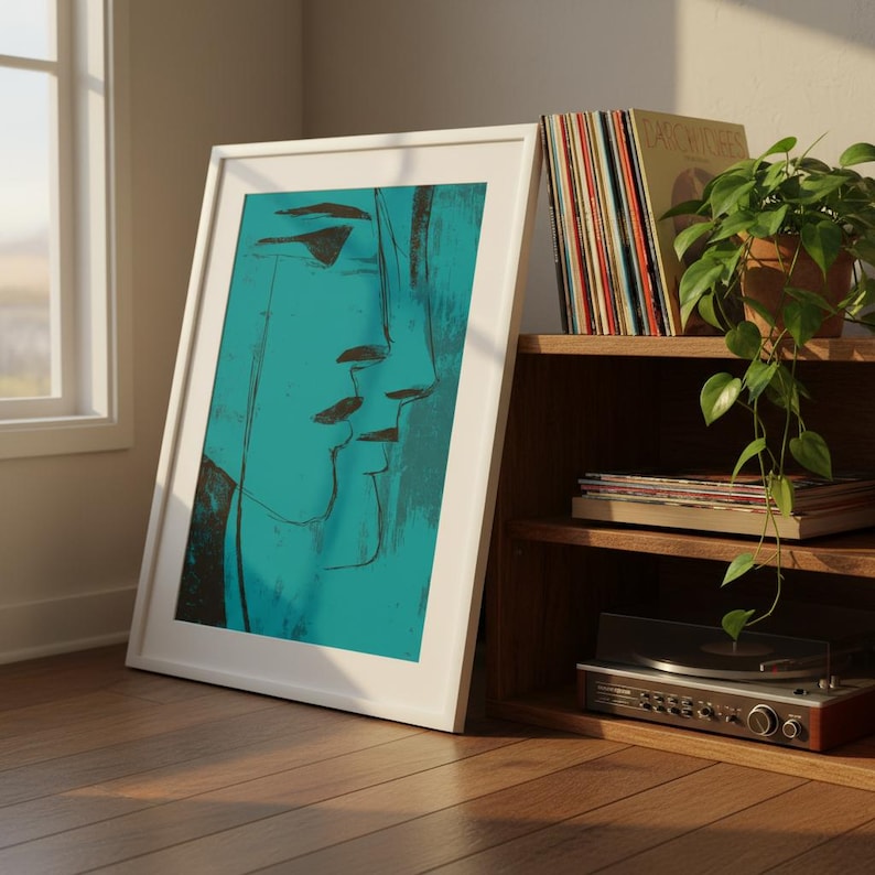 May include: A framed abstract art print featuring a teal and black face profile. The artwork is in a white frame, leaning against a wall. A wooden shelf holds vinyl records, a potted plant, and a record player, creating a vintage aesthetic.