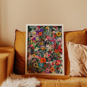K&ouml;nnte beinhalten: Ein gerahmter Kunstdruck mit einem dichten Arrangement farbenfroher Blumen in Rot-, Orange-, Gelb-, Rosa-, Lila- und Wei&szlig;t&ouml;nen. Das Kunstwerk ist vor einem dunklen Hintergrund platziert und mit einem wei&szlig;en Rahmen versehen. Der Druck wird auf einem senffarbenen Sofa pr&auml;sentiert.