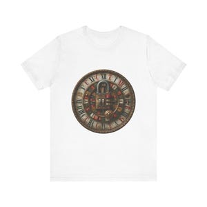 Könnte beinhalten: Ein weißes Kurzarm-T-Shirt mit einer zentralen Grafik eines kreisförmigen Zifferblatts mit römischen Ziffern in Rot und Schwarz. Ein metallisches Zahlenschloss ist über der Mitte des Zifferblatts platziert und verdeckt die Zeiger und Details.