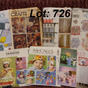 May include: A collection of seven sewing pattern envelopes from McCall's and Simplicity, featuring various craft and fashion accessory designs. The envelopes display illustrations of children's clothing, doll outfits, and home decor items. Text reads Lot: 726.