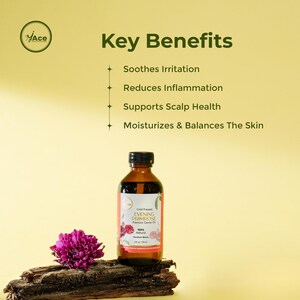 Puede incluir: Una botella de vidrio marr&oacute;n de aceite de onagra con una tapa negra, exhibida sobre un trozo de madera. La etiqueta incluye el texto "Cold Pressed Evening Primrose Premium Carrier Oil". Una flor rosa est&aacute; al lado de la botella. El fondo es amarillo.
