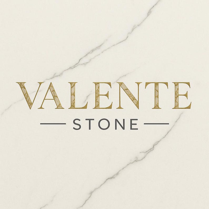 K&ouml;nnte beinhalten: Das Valente Stone-Logo wird auf einem wei&szlig;en Marmorhintergrund angezeigt. Das Wort "VALENTE" ist in goldener, stilisierter Schrift, mit dem Wort "STONE" darunter in einer kleineren, grauen Schrift. Zwei horizontale Linien trennen die W&ouml;rter.