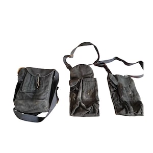Puede incluir: Tres bolsas de lona gris oscuro con correas ajustables. Las bolsas varían en tamaño y diseño, una de ellas con cierre de solapa y correa de cuero. Las otras dos tienen múltiples bolsillos y una forma más aerodinámica.