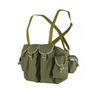 May include: Olive green chest rig with multiple pouches and adjustable straps. The rig features several flap-covered pockets secured with wooden toggles. The shoulder straps are also olive green.