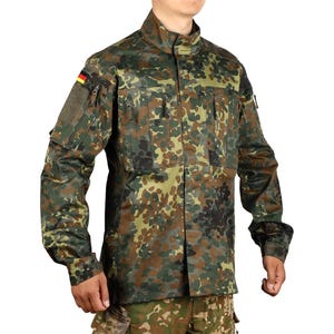 May include: A camouflage military jacket in shades of green, brown, and tan. The jacket features multiple pockets, a stand-up collar, and a German flag patch on the left shoulder. The fabric has a mottled pattern.