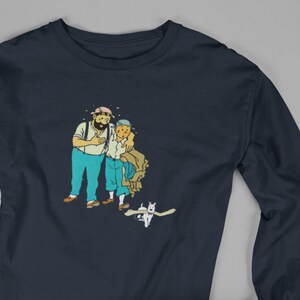 May include: Navy blue long-sleeve shirt featuring a cartoon illustration of two men and a dog. The men are in blue pants and white shirts. The dog is white. The shirt is made of a soft, comfortable material.