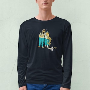 May include: Black long-sleeve shirt featuring a cartoon illustration of two people and a cat. The cartoon characters are wearing blue pants and white shirts. The background is a light green color.