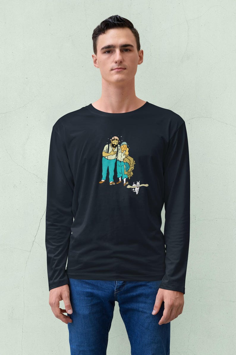 May include: Black long-sleeve shirt featuring a cartoon illustration of two people and a cat. The cartoon characters are wearing blue pants and white shirts. The background is a light green color.