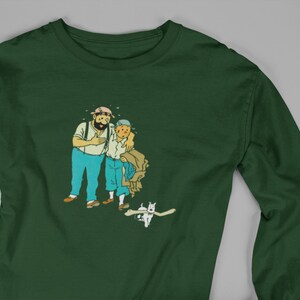 May include: Dark green long-sleeve shirt featuring a cartoon illustration of two men and a dog. The men are in blue pants and white shirts. The dog is white with a bone in its mouth. The shirt is made of a soft, comfortable material.