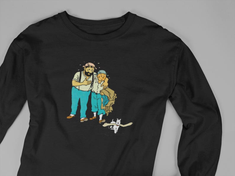 May include: Black long-sleeve shirt featuring a cartoon illustration of two men and a dog. The men are in blue pants and white shirts, with one wearing a hat. The dog is white with a bone in its mouth.