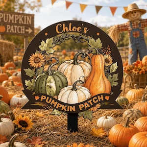 Könnte beinhalten: Ein rundes Gartenschild mit der Aufschrift Chloe's PUMPKIN PATCH, verziert mit Illustrationen von drei Kürbissen in Grün-, Weiß- und Orangetönen, umgeben von Sonnenblumen und Herbstblättern auf einem dunkelbraunen Hintergrund.