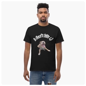 Könnte beinhalten: Schwarzes T-Shirt mit einem Hunde-Motiv und dem Text "I don't bite :)". Der Hund ist hellbraun und weiß, mit herausgestreckter Zunge. Der Text ist weiß und über dem Hundebild gebogen.