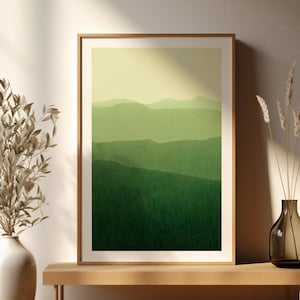 May include: A framed print of a green landscape, with a gradient of shades representing hills. The artwork is displayed on a wooden bench, with a vase of dried plants and a decorative vase. The style is minimalist and modern.