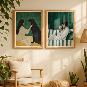 Puede incluir: Dos impresiones artísticas enmarcadas con marcos de madera. Una representa a una persona con un perro negro, la otra a una persona bebiendo té. Las impresiones cuelgan de una pared beige, con una silla de madera, plantas y una lámpara tejida.