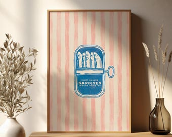 Könnte beinhalten: Gerahmter Druck mit einer blauen Sardinenbüchsen-Illustration auf einem rosa-weiß gestreiften Hintergrund. Die Dose zeigt mehrere Fische. Der Text auf der Dose lautet "Finest Smoked Sardines in Pure Olive Oil".