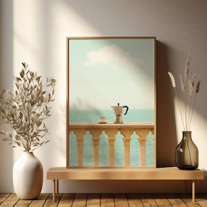 May include: A framed art print depicts a serene coastal scene with a coffee maker and cup on a balcony overlooking the sea. The artwork is displayed on a wooden bench, complemented by a vase with dried plants and a large vase with dried leaves.