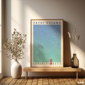 Może przedstawiać: Oprawiony wydruk artystyczny z napisem "YAYOI KUSAMA" w kolorze niebieskim i "INFINITY NETS" w kolorze zielonym. Grafika przedstawia gradient niebieskich i zielonych kropek. Wydruk znajduje się na drewnianej ławce z wazonem i suszonymi roślinami.
