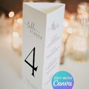 May include: A white, triangular table number card with the number 4 in black. The card also features the words "table number" and "the menu" in elegant script, along with a list of menu items. The bottom of the card has names and a date.