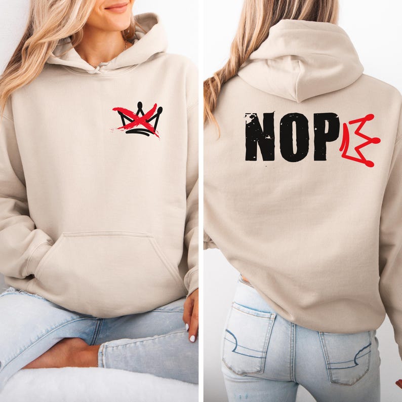 May include: Beige hoodie with a front pocket and a hood. The front features a red and black crown graphic. The back of the hoodie displays the word "NOPE" in black, with a red crown graphic on the right side.
