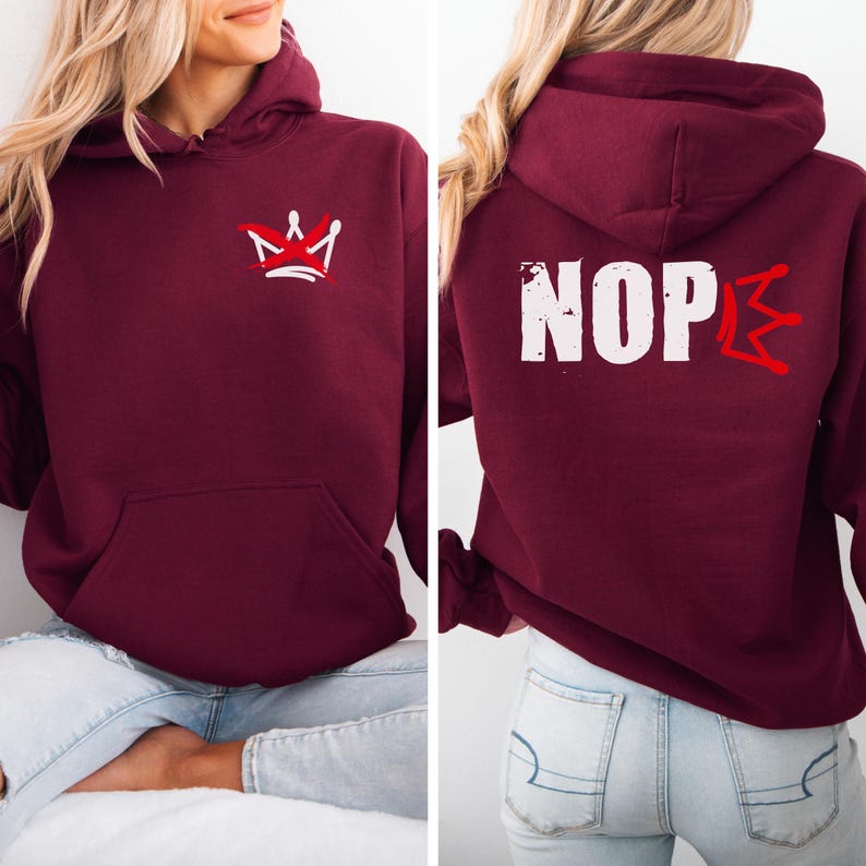 May include: Burgundy hoodie with a front pocket and a hood. The front features a white and red crown graphic. The back of the hoodie displays the word "NOPE" in white, with a red crown graphic. A casual, comfortable garment.