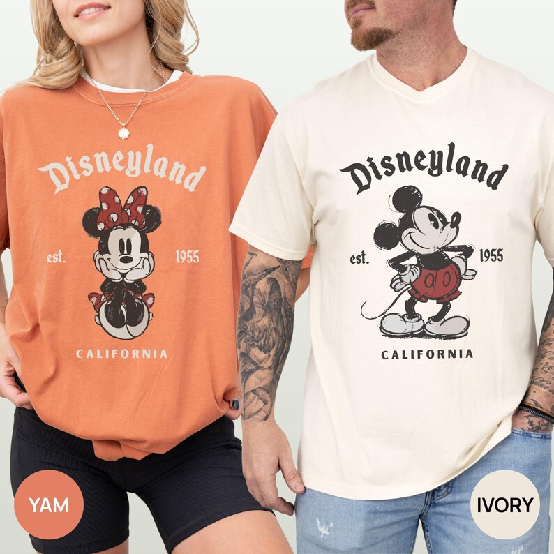 Puede incluir: Dos camisetas, una color &ntilde;ame y otra marfil, con un dise&ntilde;o vintage de Disneyland con Mickey y Minnie Mouse. Las camisetas tienen el texto "Disneyland est. 1955 CALIFORNIA".