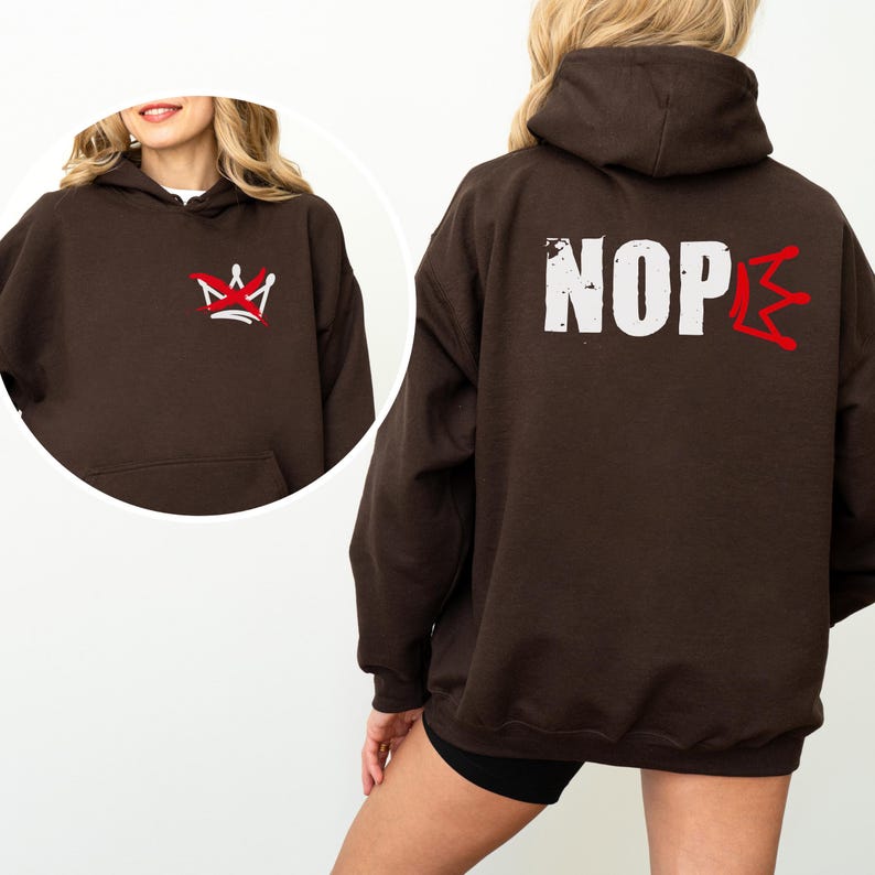 May include: A dark brown hoodie with a front pocket and a hood. The front features a red and white crown design. The back displays the word "NOPE" in white block letters with a red lightning bolt-like design replacing the "E".