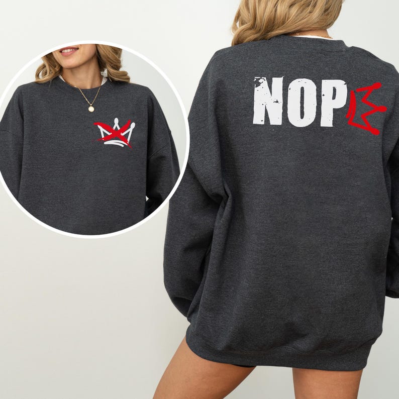 May include: Dark gray sweatshirt with a red and white crown graphic on the front and the word "NOPE" in white with a red accent on the back. The sweatshirt is a casual style.