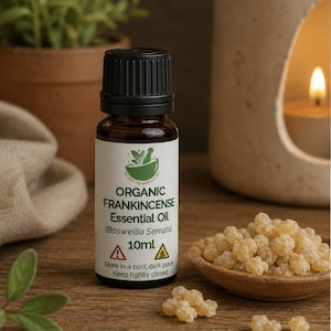 May include: A 10ml amber glass bottle of organic frankincense essential oil with a black cap. The white label features a green mortar and pestle icon, the text "ORGANIC FRANKINCENSE Essential Oil (Boswellia Serrata) 10ml", and warning symbols.