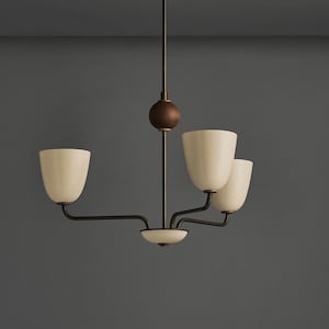 May include: A modern chandelier with a dark bronze finish. It features three off-white, tulip-shaped shades and a central wooden sphere. The fixture is suspended from a ceiling mount, creating a stylish lighting element.