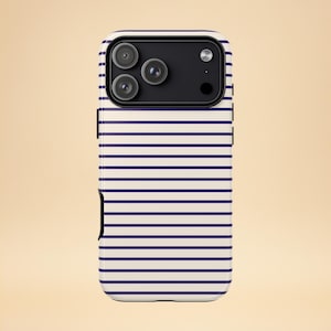 Puede incluir: Una funda de teléfono con un fondo crema y rayas horizontales azul marino. La funda tiene un módulo de cámara negro con tres lentes. La funda está diseñada para adaptarse a un teléfono inteligente.
