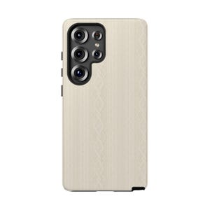 Pu&ograve; includere: Una custodia per telefono color crema con un motivo a trecce. La custodia ha un modulo fotocamera nero con pi&ugrave; lenti e una cornice nera. La custodia del telefono &egrave; progettata per proteggere il telefono da graffi e danni.