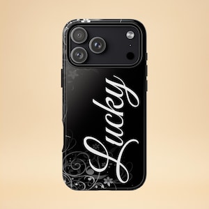 Könnte beinhalten: Schwarze Handyhülle mit dem Wort "Lucky" in weißer Schrift. Die Hülle hat ein florales Design in Weiß und Grau auf schwarzem Hintergrund. Die Handyhülle hat eine Kamera und einen Blitz.