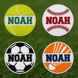 Puede incluir: Cuatro parches circulares bordados con temas deportivos. Arriba a la izquierda, una pelota de tenis amarilla con el texto verde NOAH. Arriba a la derecha, una pelota de béisbol blanca con costuras y texto rojo NOAH. Abajo a la izquierda, un balón de fútbol blanco y negro con texto negro NOAH. Abajo a la derecha, un volante de bádminton naranja con texto azul oscuro NOAH.