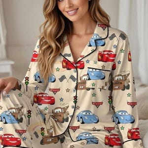 Zoom into dreamland with this Cars Satin Pajama Set, featuring Lightning McQueen, Mater, and Sally against a playful beige racing backdrop. Perfect for Pixar fans, kids, and parents who love cozy, matching sleepwear with a fun race day vibe 🏆🚗💨