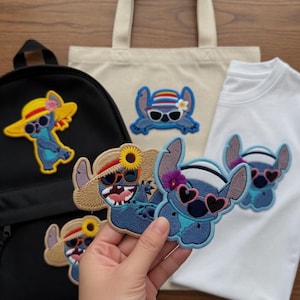 Può includere: Toppe e accessori ricamati con un personaggio blu dei cartoni animati che indossa occhiali da sole e cappelli. Gli articoli includono uno zaino nero, una maglietta bianca e una borsa tote beige. Le toppe hanno vari disegni, tra cui un girasole e occhiali da sole a forma di cuore.