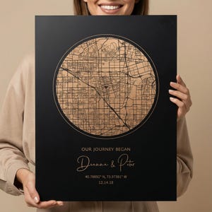 Puede incluir: Impresión enmarcada en negro con un mapa detallado en tono dorado dentro de un círculo. El texto "OUR JOURNEY BEGAN" está sobre los nombres "Dianna & Peter". También incluye coordenadas y la fecha 12.14.18.