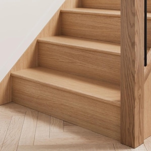 Könnte beinhalten: Nahaufnahme einer Holztreppe mit drei sichtbaren Stufen. Die Stufen und die tragende Struktur bestehen aus hellem Holz und zeigen eine natürliche Maserung. Das Design ist schlicht und modern, mit einer weißen Wand auf der linken Seite.
