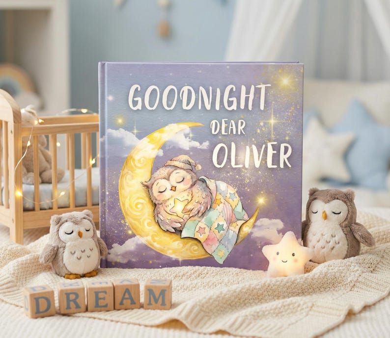 May include: A children's book titled "Goodnight Dear Oliver" with an illustration of a sleeping owl on a crescent moon. The image includes two plush owl toys, wooden blocks spelling "DREAM", and a star-shaped night light.