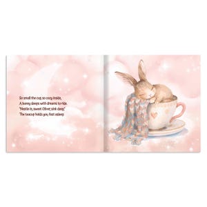 May include: A children's book illustration shows a sleeping bunny nestled in a teacup. The bunny is covered with a blue and white patterned blanket. The teacup is white with a pink handle and a heart design. The background is a soft pink with text.