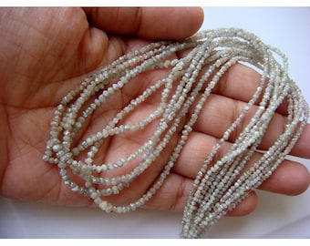 May include: A strand of white rough diamond beads. The beads are small and have a natural, unpolished look. The beads are strung on a thin thread and are arranged in a loose, flowing pattern.