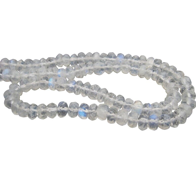 Peut inclure: Un brin de perles de pierre de lune blanche iris&eacute;e. Les perles sont facett&eacute;es et ont une forme l&eacute;g&egrave;rement irr&eacute;guli&egrave;re.