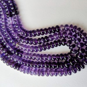 May include: A strand of amethyst beads, featuring a deep purple color with a slight variation in shade. The beads are round and smooth, with a polished finish.