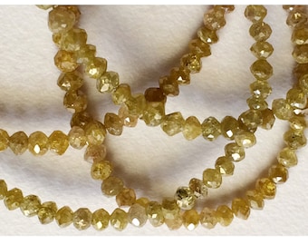 May include: A strand of yellow-green rough diamond beads. The beads are faceted and have a natural, unpolished look.