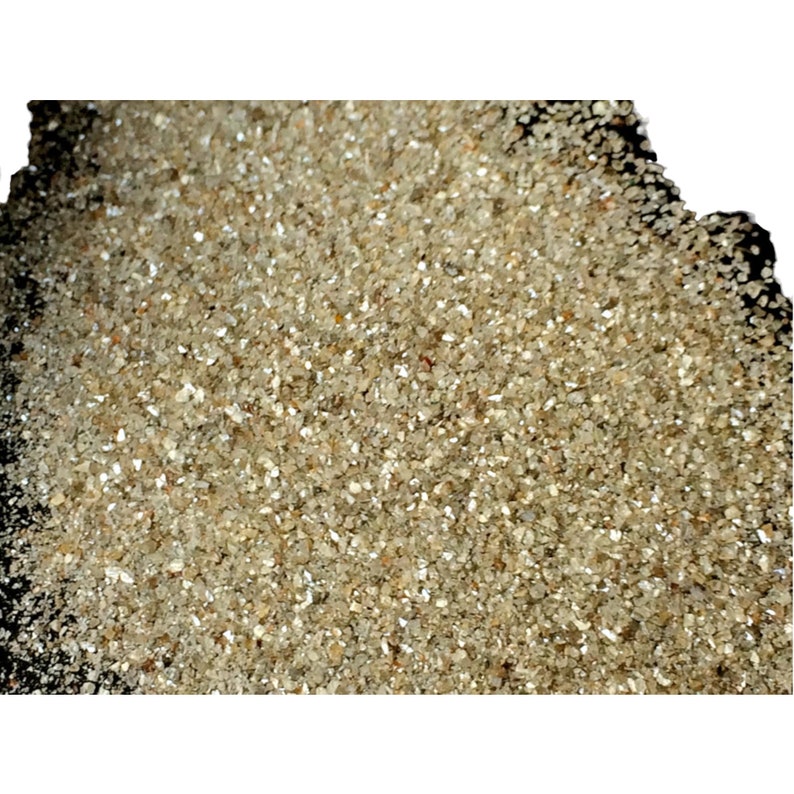 May include: A close-up view of a pile of small, light brown, sparkly, rough-cut diamonds.