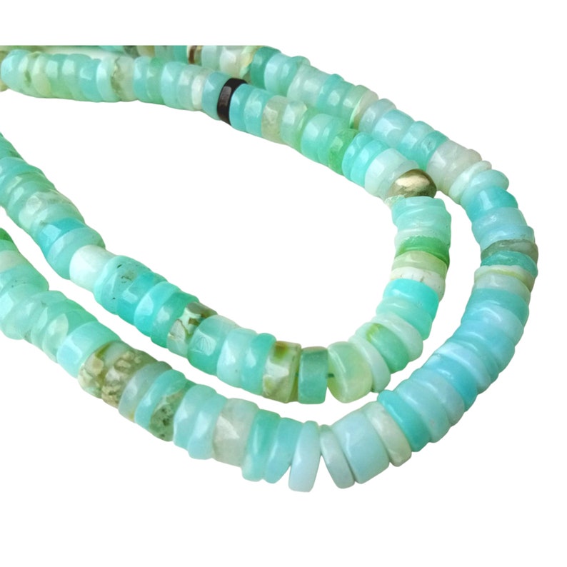 May include: A strand of turquoise blue opal beads, each bead is a different shade of blue and green, and has a slightly irregular shape.