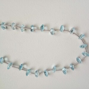 May include: A strand of light blue gemstone beads strung on silver wire.