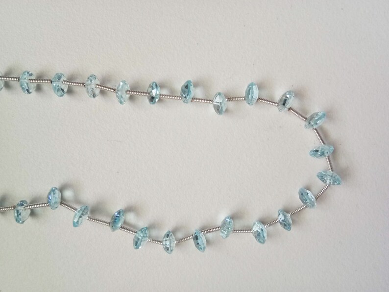 May include: A strand of light blue gemstone beads strung on silver wire.